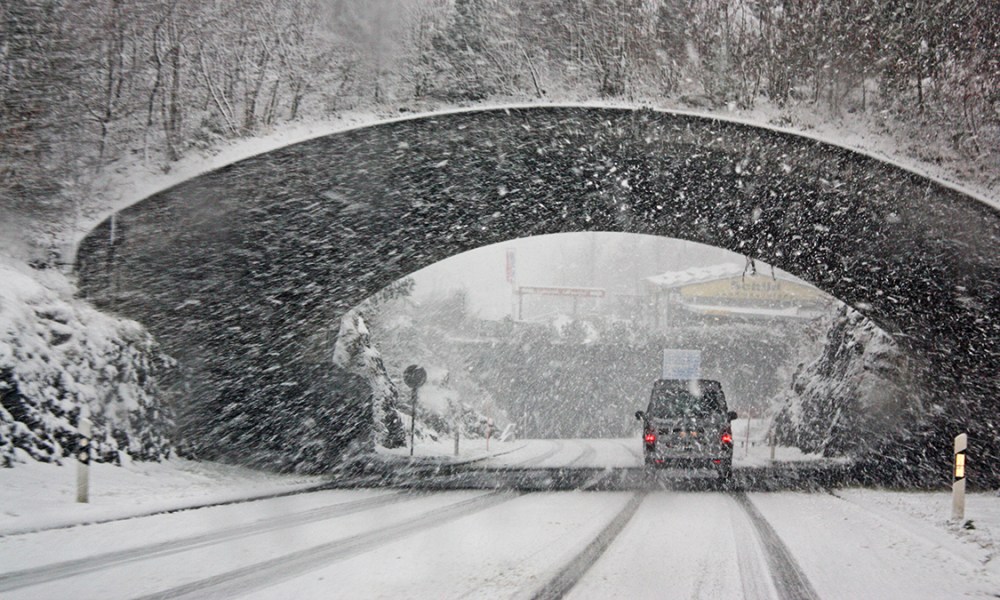 Car in the snow under an overpass