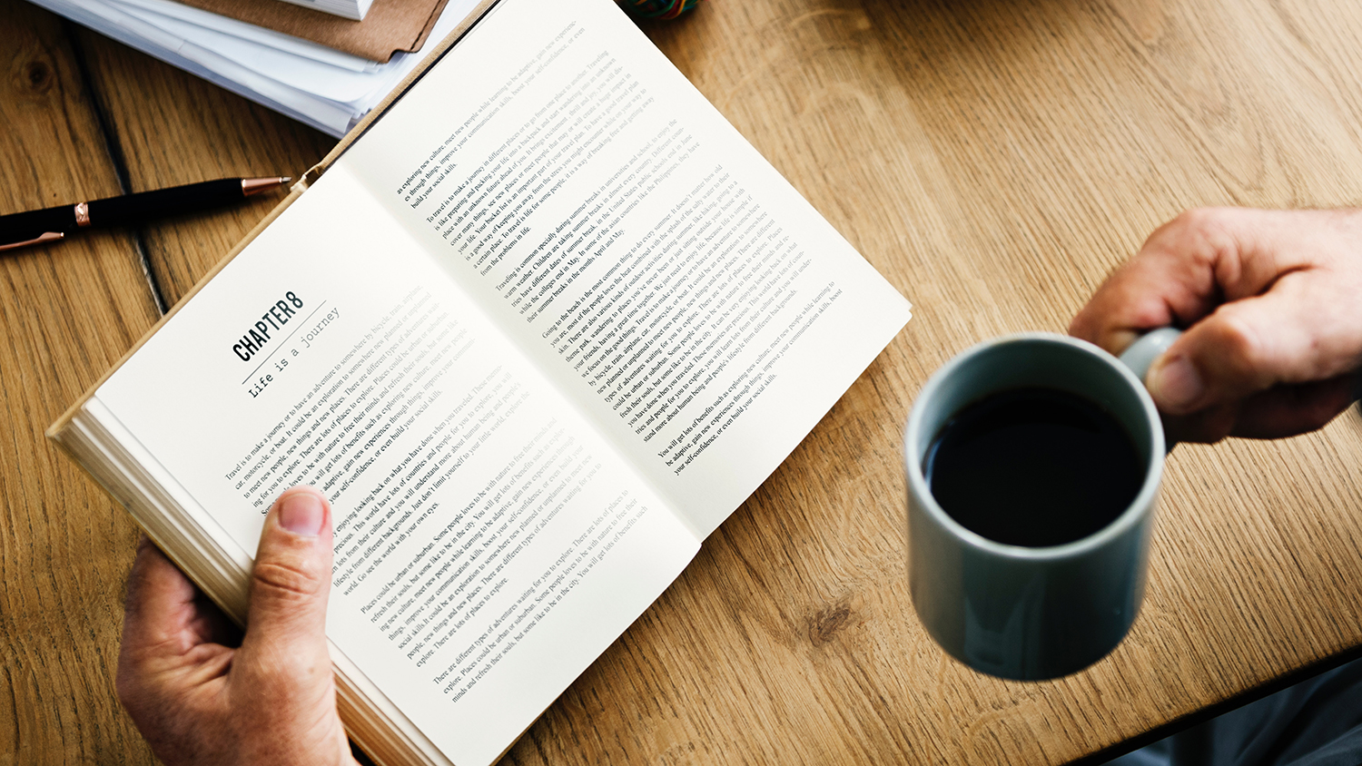 Man reading a book and drinking coffee