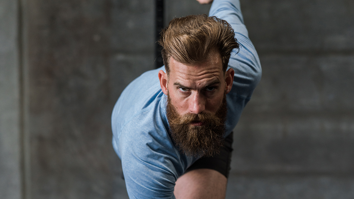 Bearded man looking confidently at the camera in a runner's starting position.