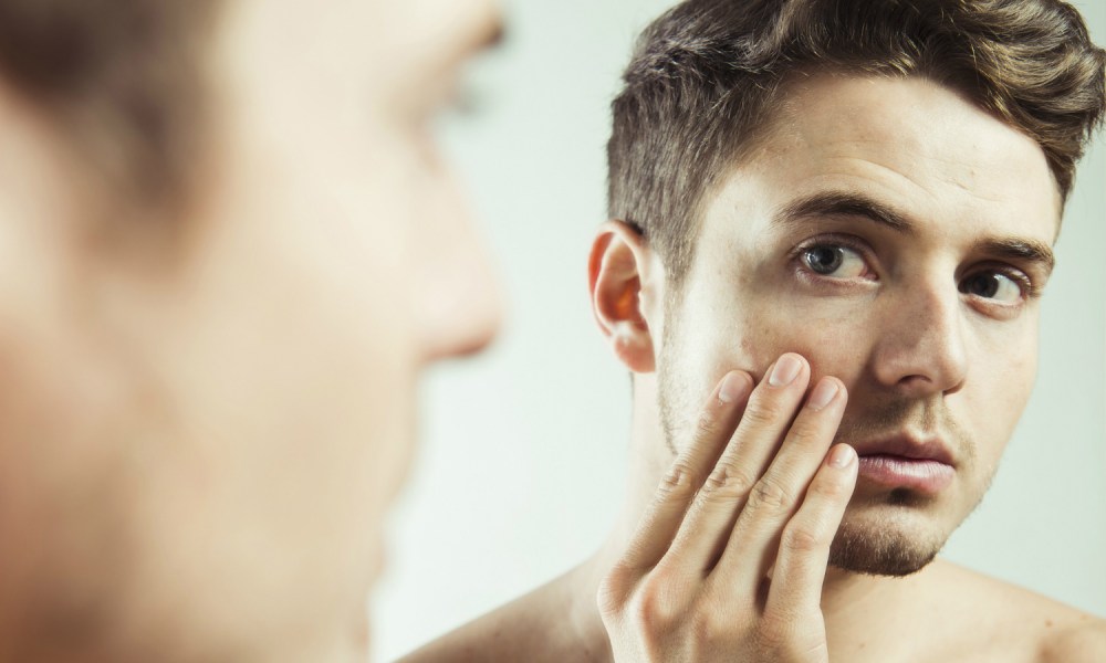 Man checking out ingrown hair in the mirror