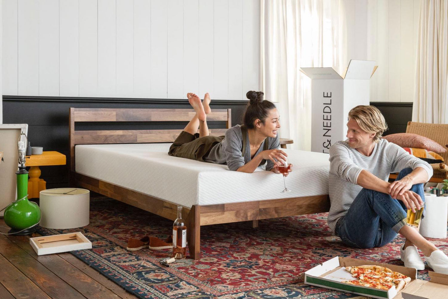 A couple eating after unboxing the Tuft & Needle memory foam mattress.