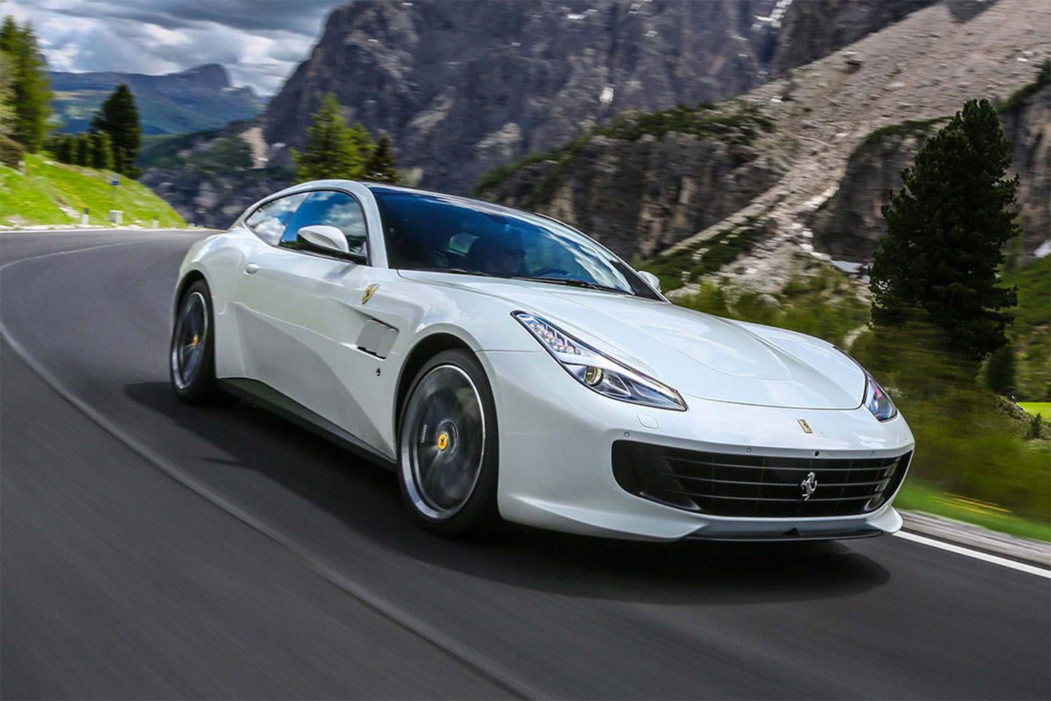 Silver Ferrari GTC4Lusso in a mountain road.