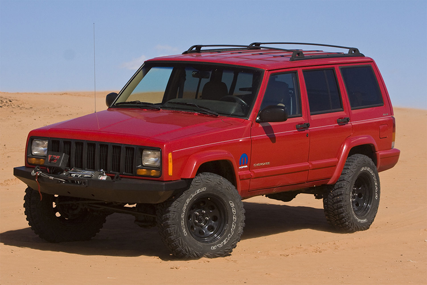 Red Jeep Cherokee XJ in a dirt road.