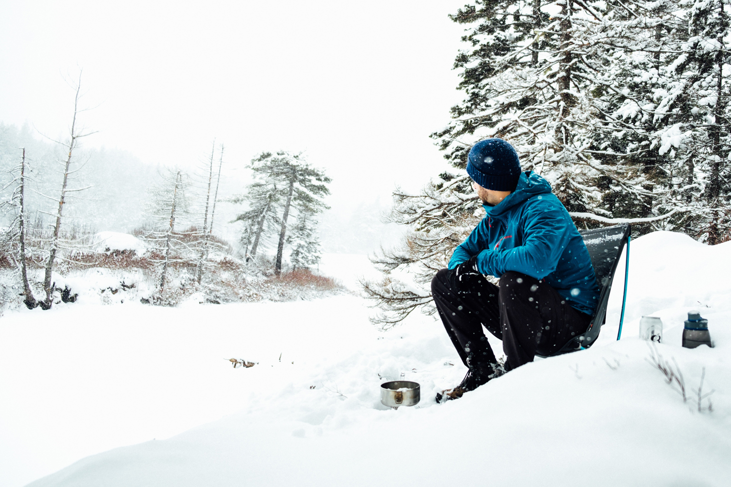 Man sitting in a chair on a snowy slope.