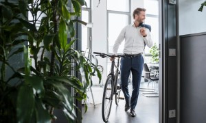 man in suit commuting in to work on bike