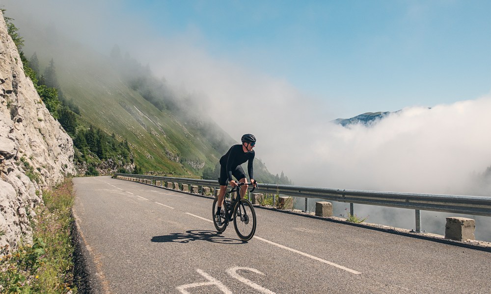 man cycling through France on road blue sky in background