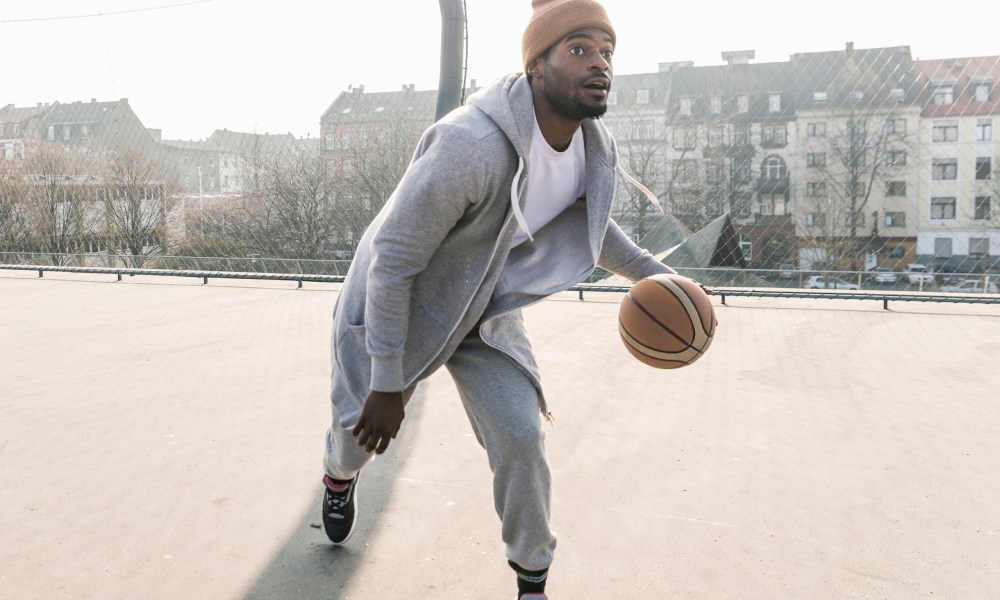 Man wearing athletic outfit while playing basketball.