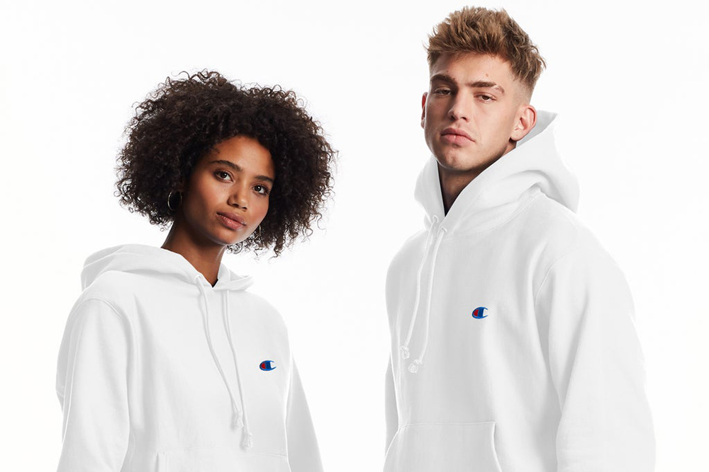 A man and women wearing Champion hoodies in white.