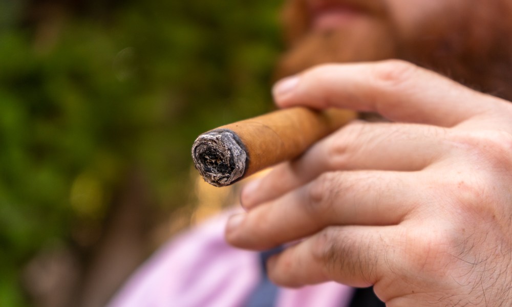 Close-up of a man smoking a cigar.