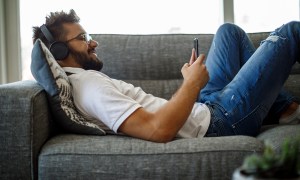 man reading audible books on the couch.