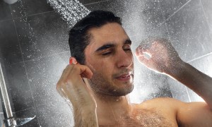 Man taking a shower washing his hair.