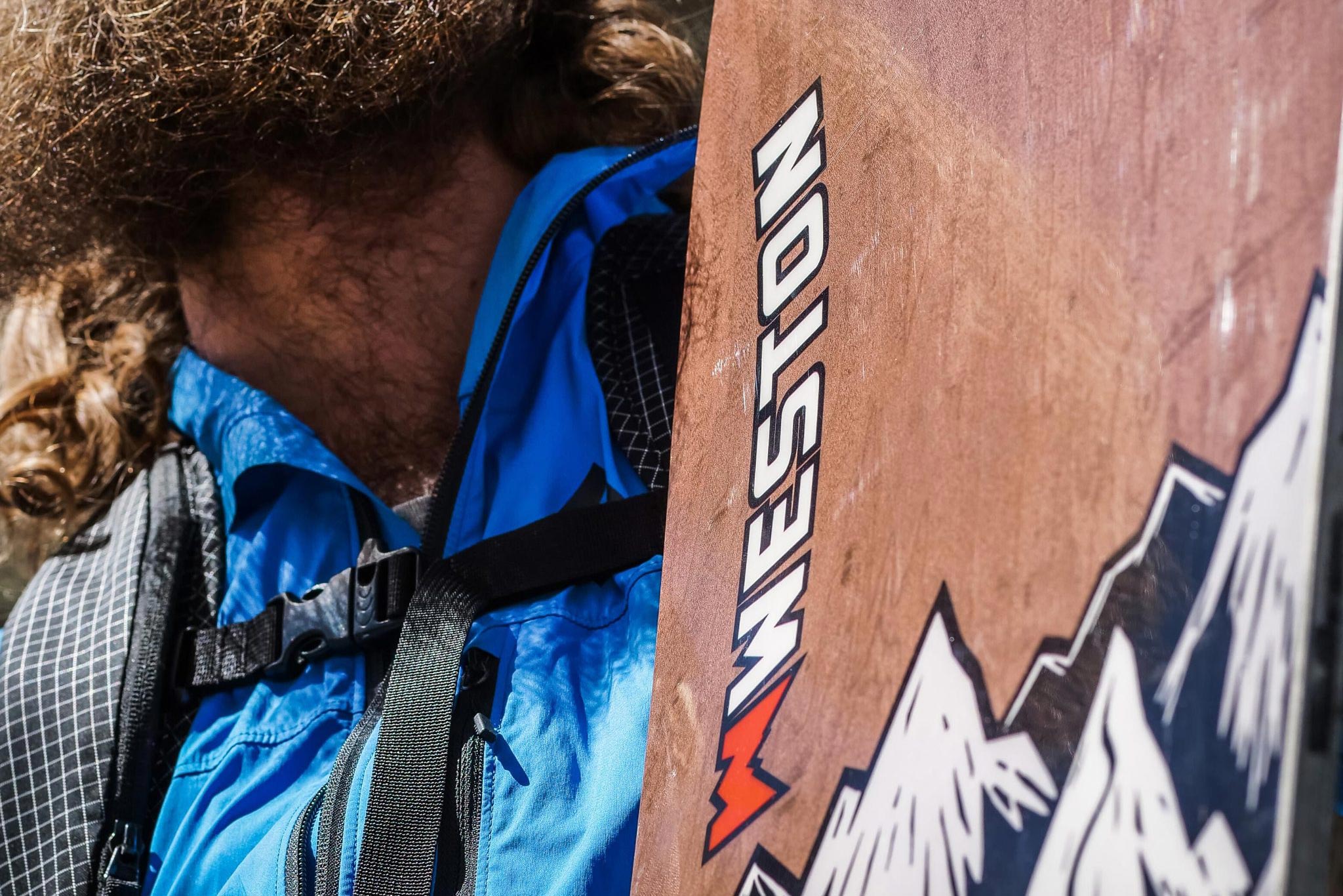 Closeup of snowboarder holding Weston Backcountry Backwoods Snowboard.