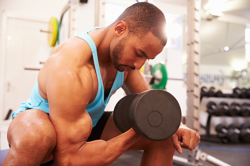 Man doing dumbbell concentration curls.