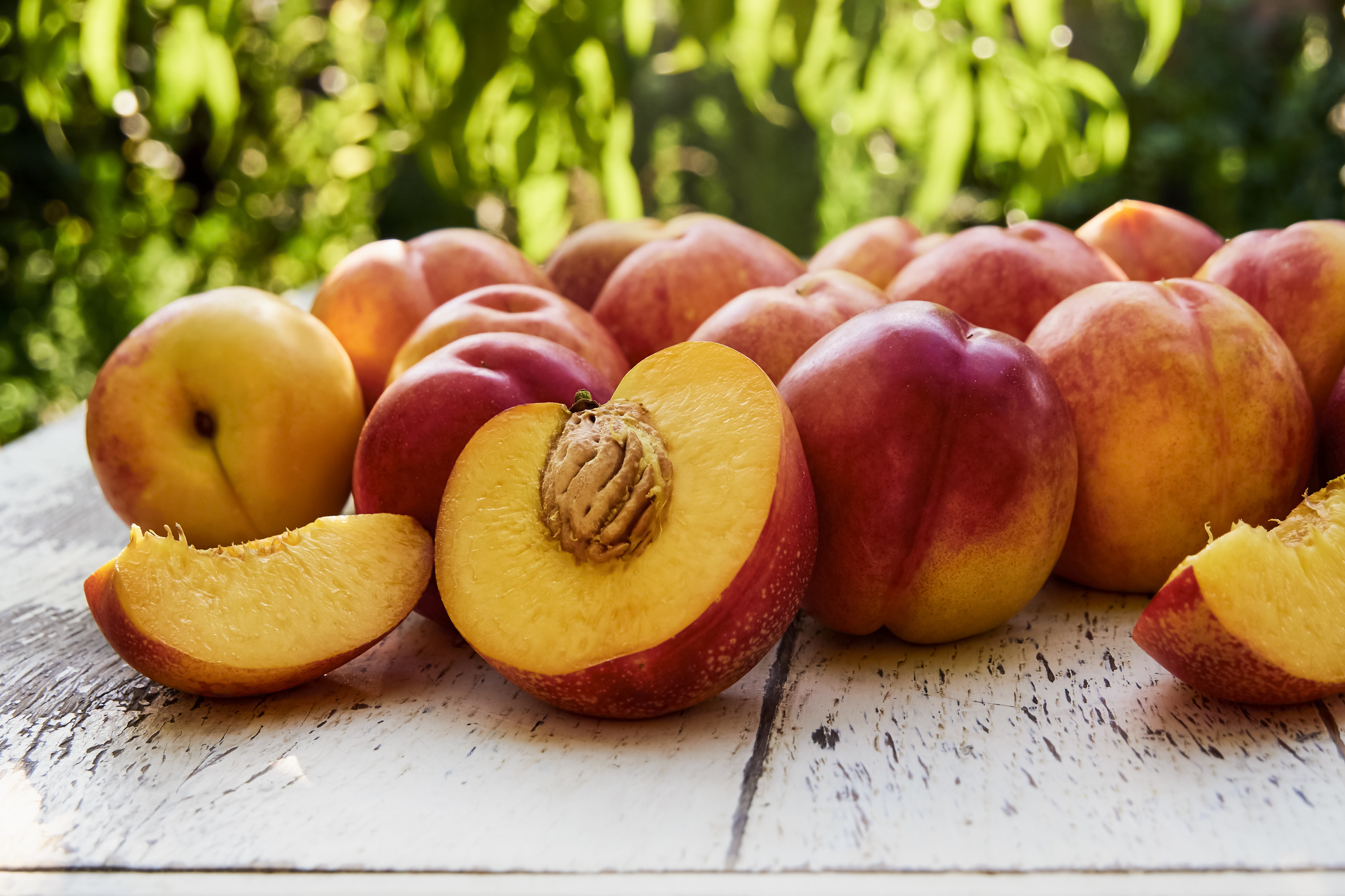 Ripe peaches with leaves on the old wooden table