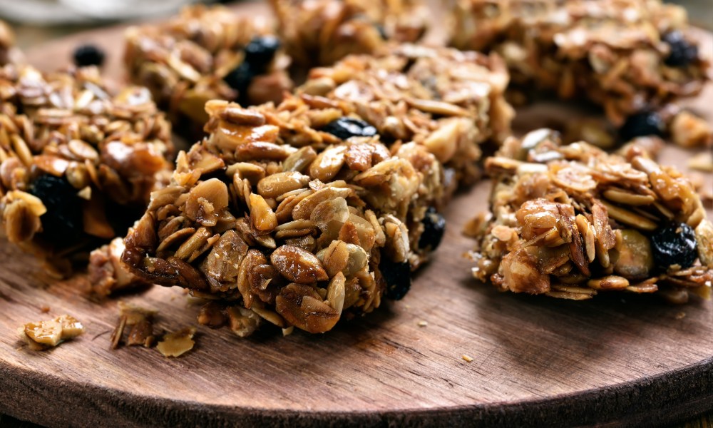 Granola pieces on wooden board, close up view