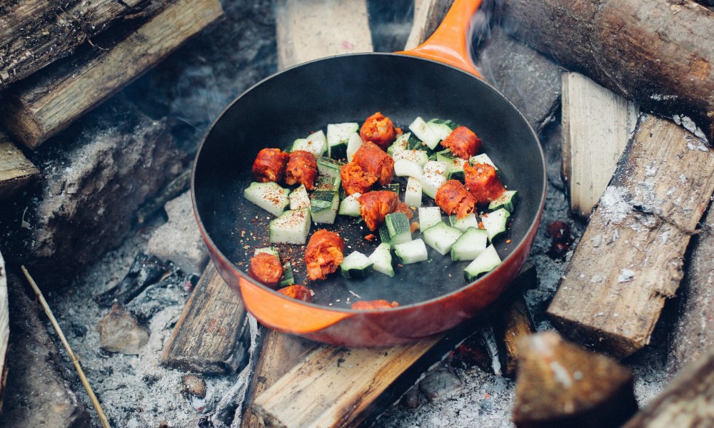 Cast-iron skillet over campfire wood