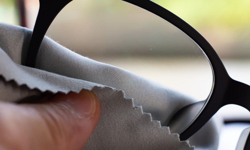 man cleaning glasses with a cloth.