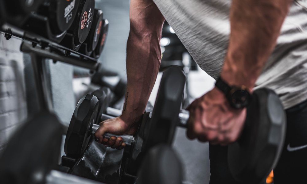 A man picking up a set of dumbbells.