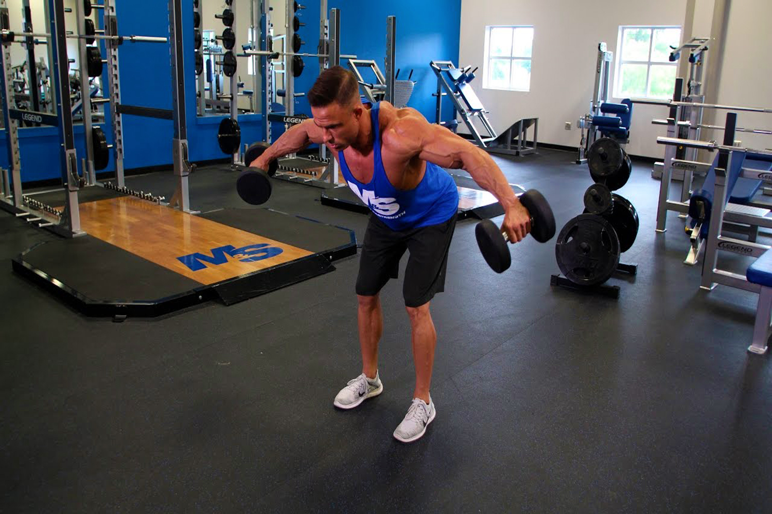 Man trying out a Bent-Over Reverse Fly with a dumbbell in each hand
