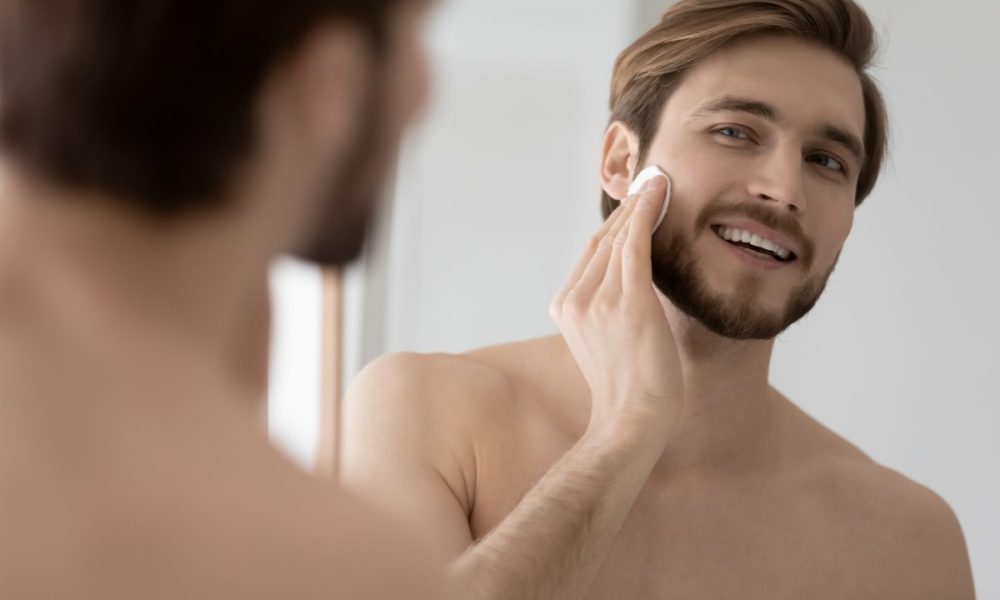 A man applying skincare products to his face.