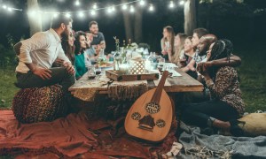 Group of people sitting around a table in an outdoor space