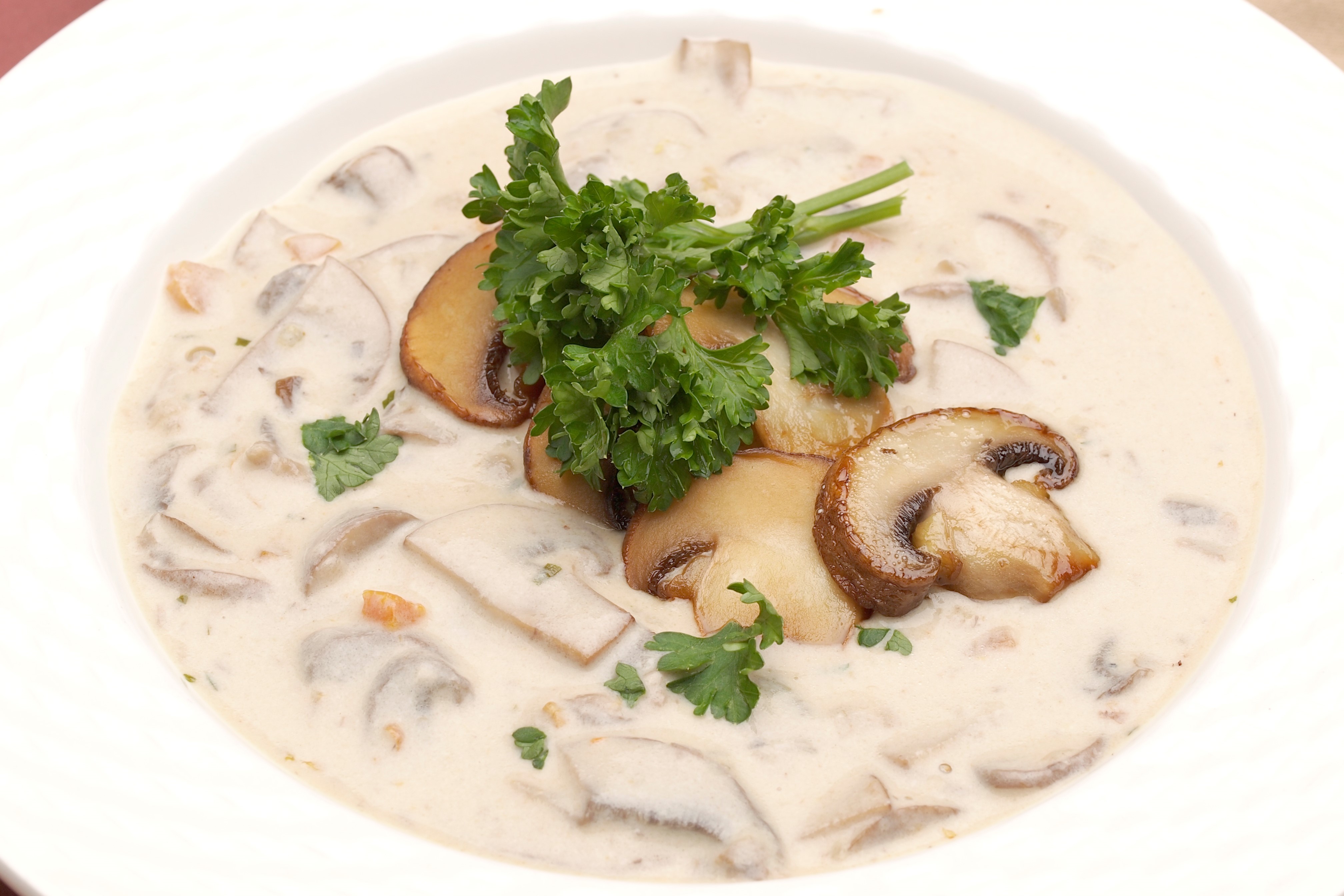 Bowl of cream of mushroom soup garnished with sauteed crimini mushrooms