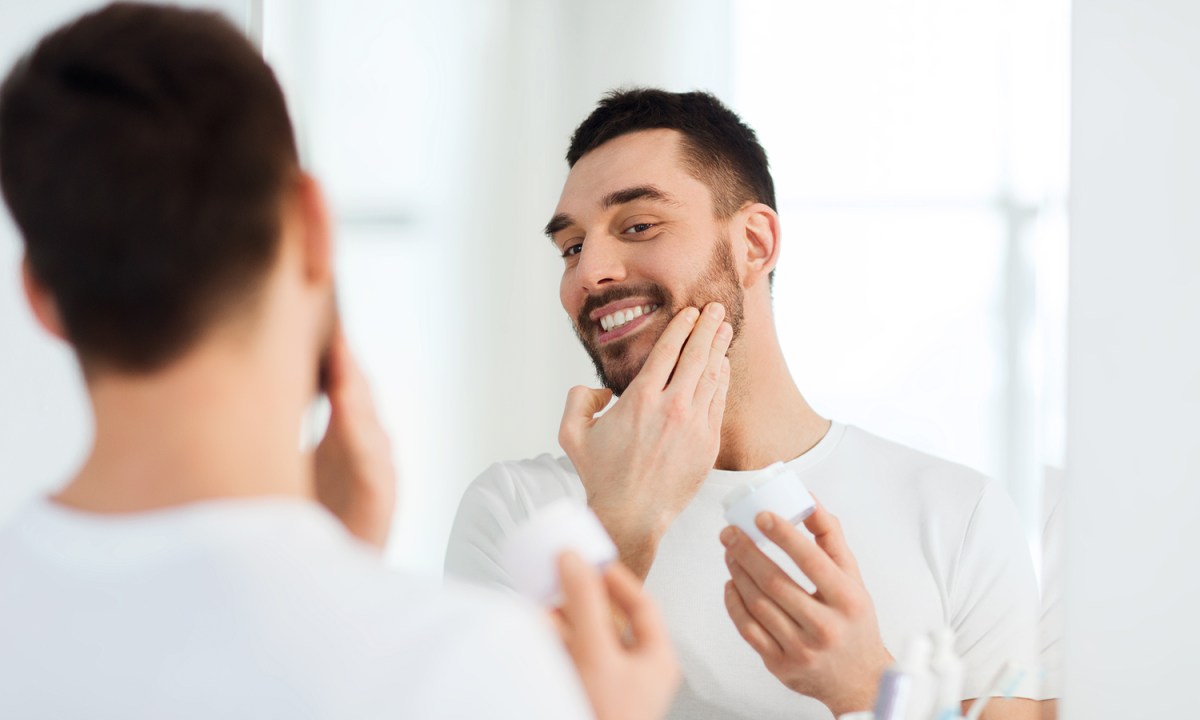 Man applying beard growth oil