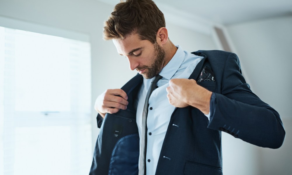 A man putting on his blazer