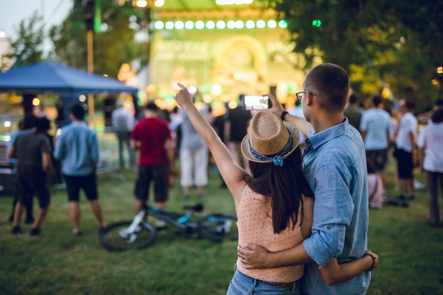 A couple taking a selfie during an outdoor concernt.