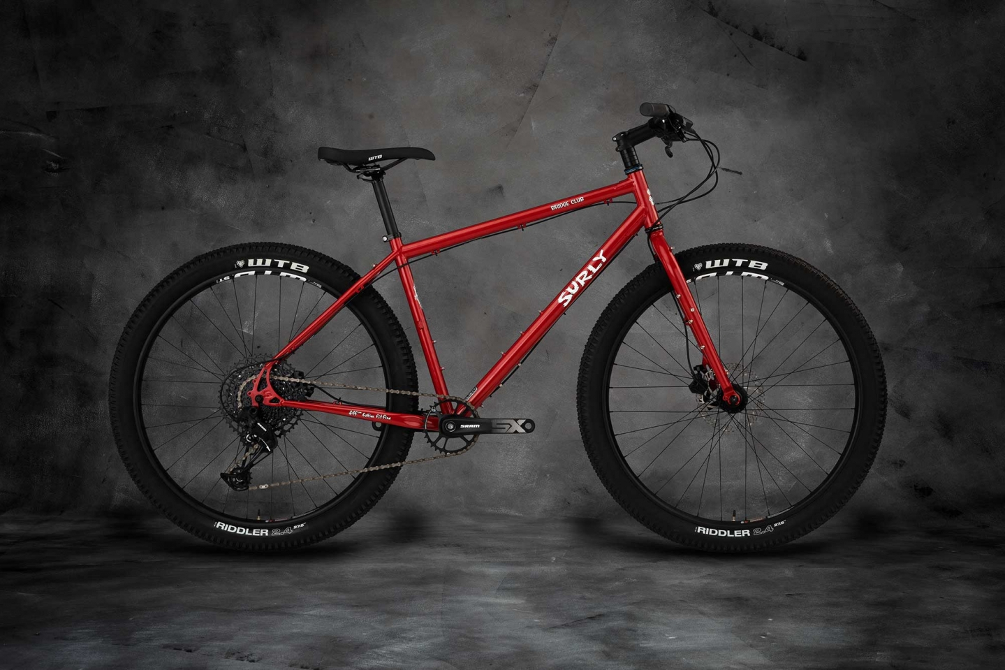 Surly Bridge Club All Road Touring Bike in red on a dark studio background.