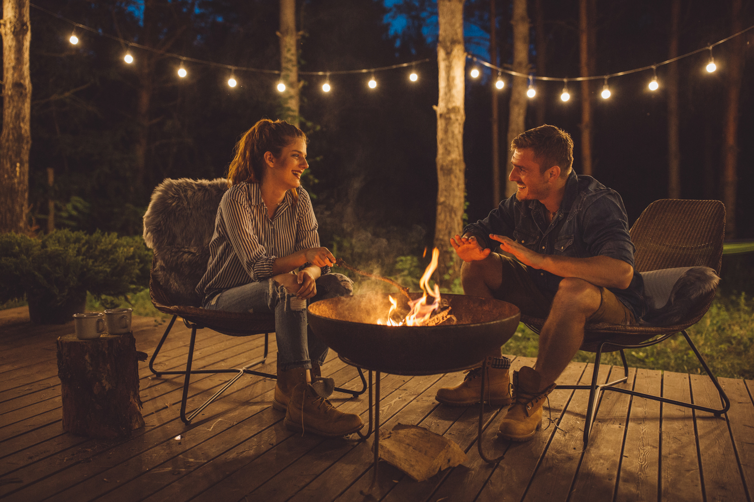 A couple talking on the porch at night.