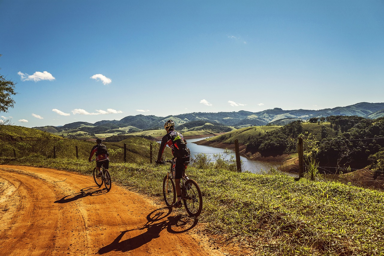 Two men cycling on a dirt road