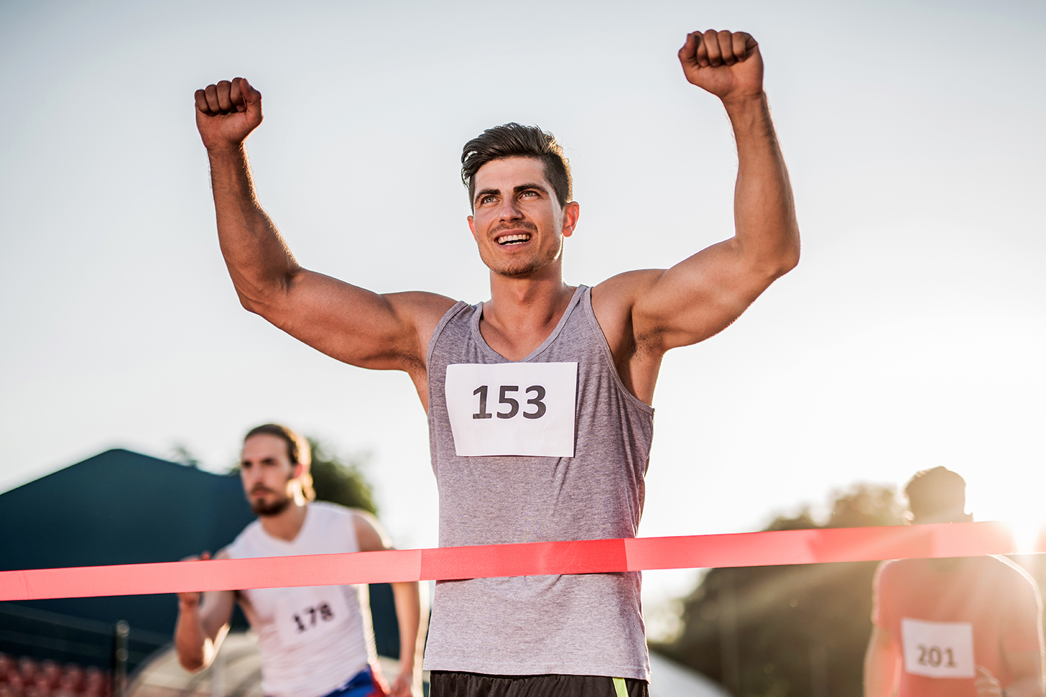 Young happy man celebrating his success after crossing the finish line and winning the race.