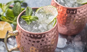 Moscow mule drinks in copper mugs garnished with lime and mint