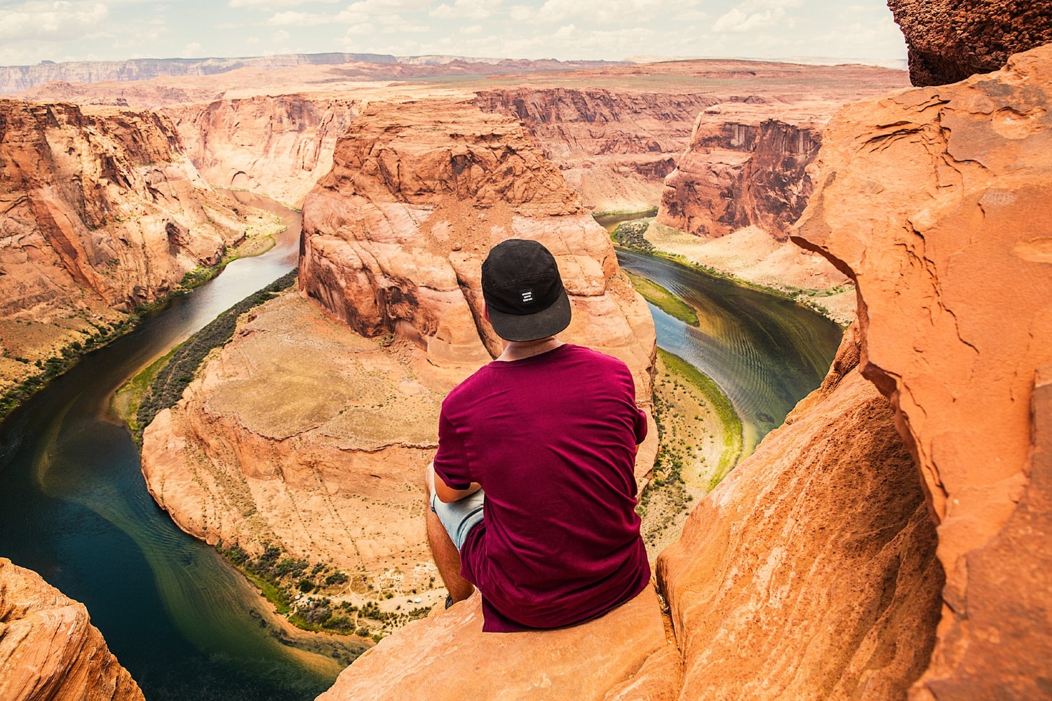 Man sitting on the rock overlooking Horsehoe Bend