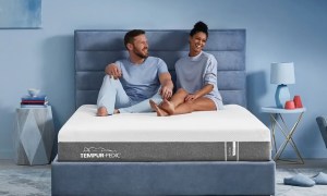 A couple sitting on a Tempur-Pedic Tempur-Cloud Mattress.