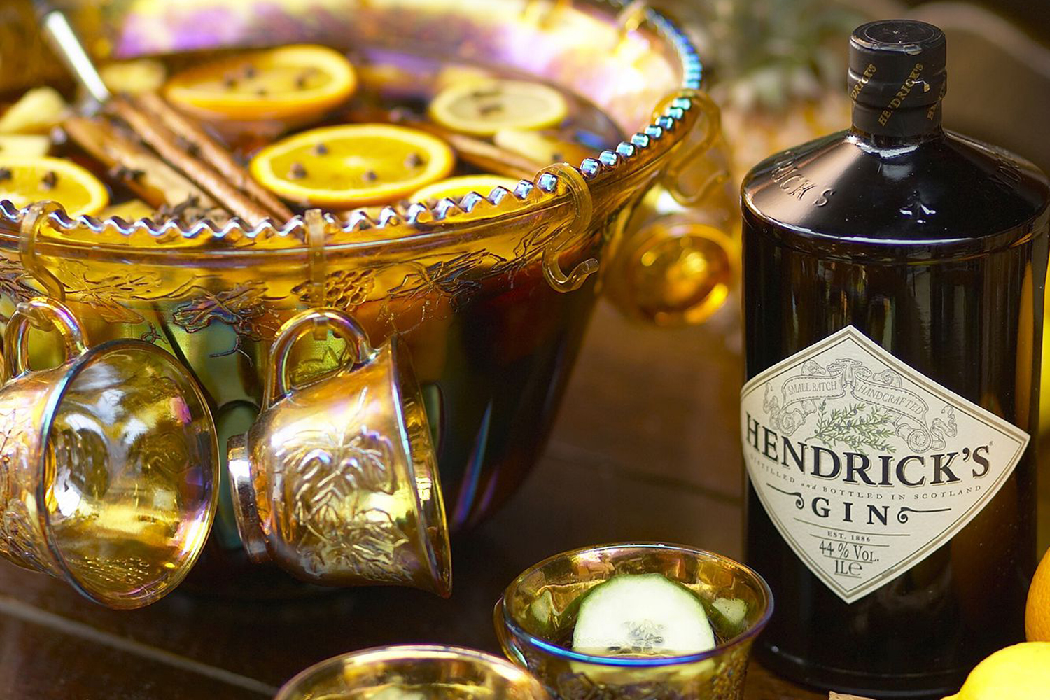 A bowl of Hendrick's hot gin punch beside a bottle of Hendrick's gin.