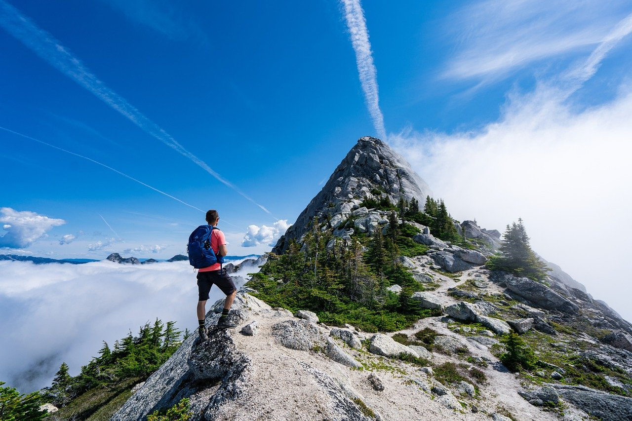 man hiking on rocky mountain peak