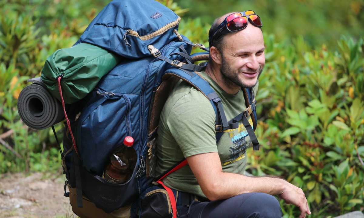 A hiker carrying his hiking pack and gear.