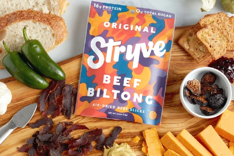 Styve Biltong on a cutting board with cheese.