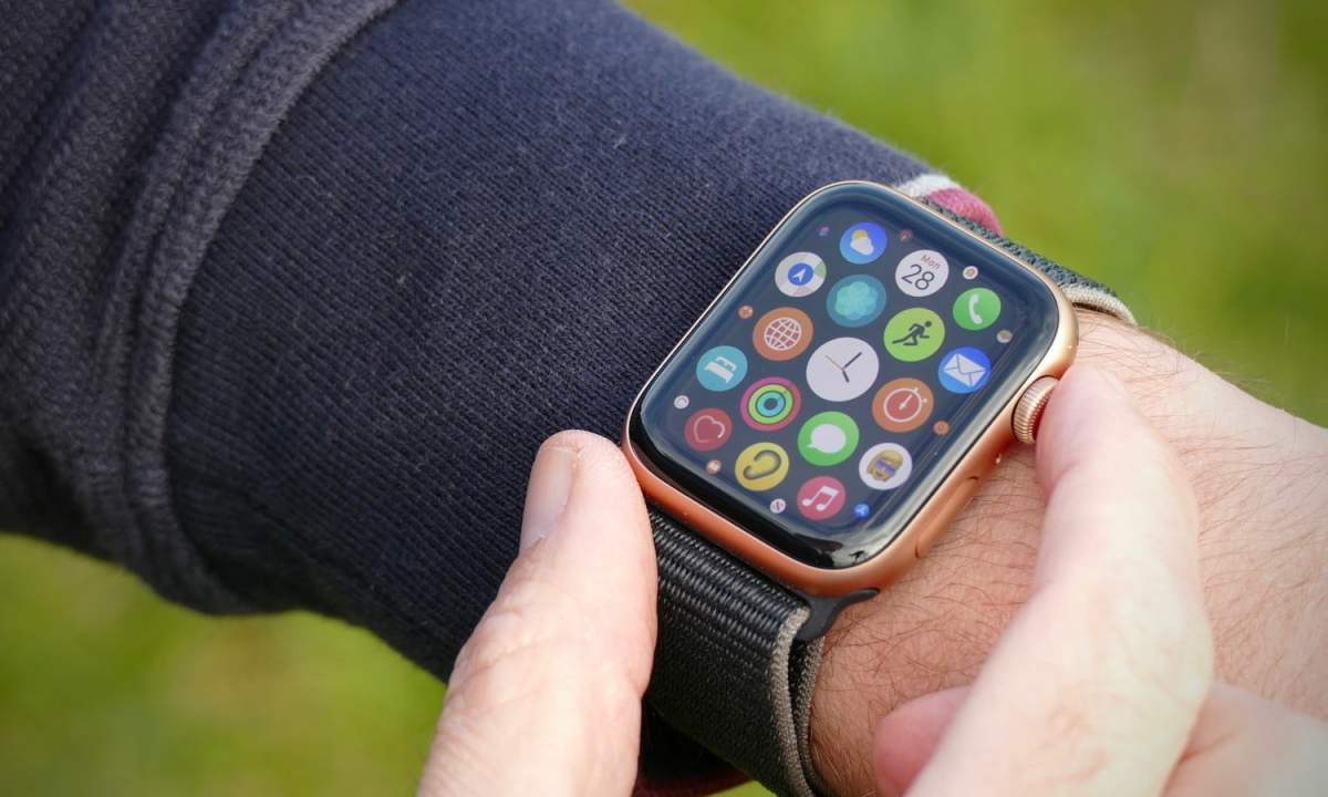 An Apple Watch SE being worn on someone's wrist with the apps displayed on its screen.