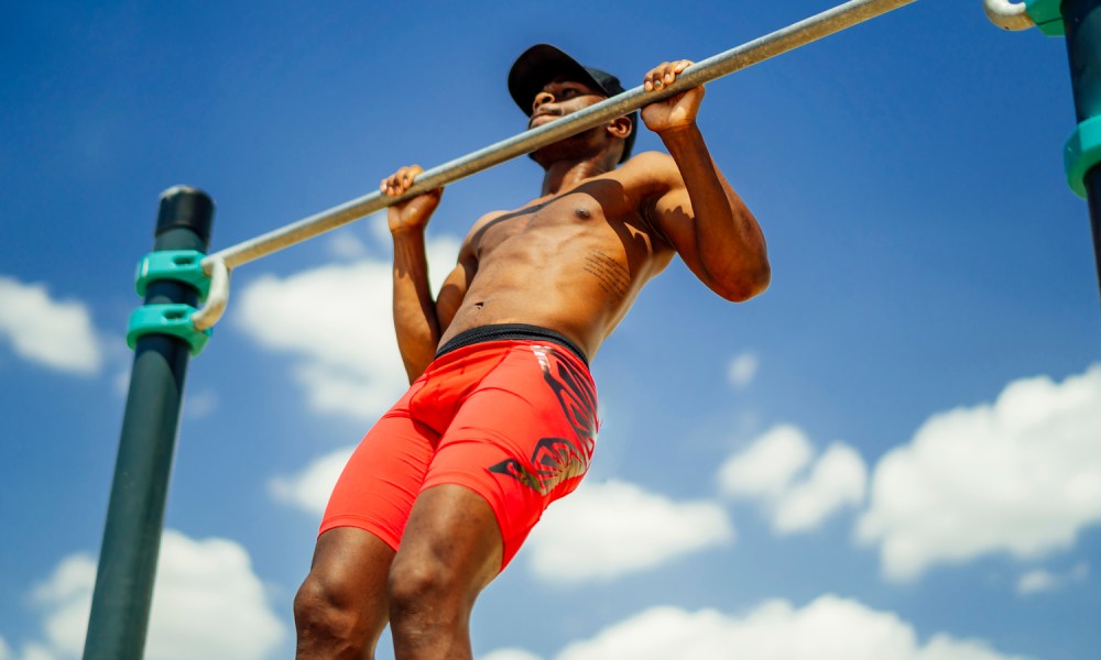 An athlete using a barbell outside on a sunny day