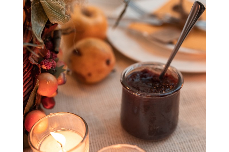 Cranberry sauce in a glass jar on a festive autumn table