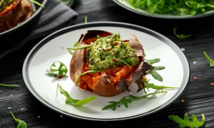 A baked sweet potato boat on a plate.