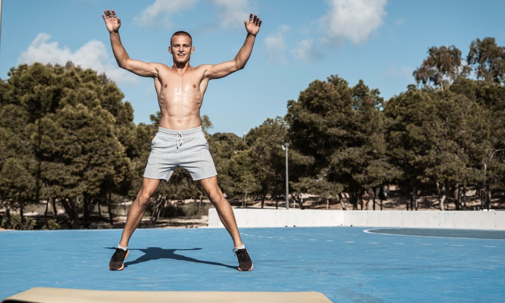 Shirtless man doing jumping jacks