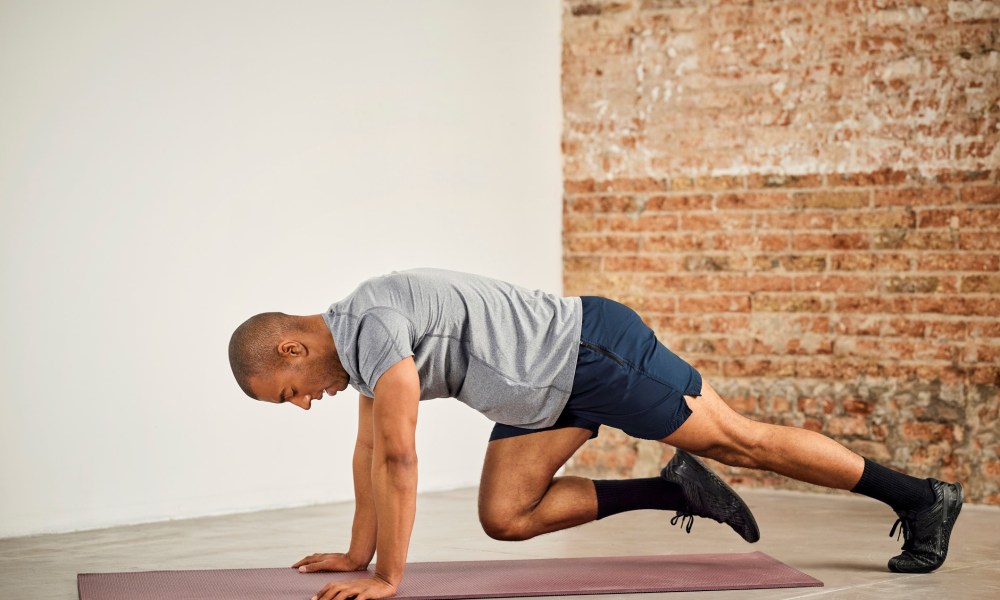 Man doing mountain climbers on a mat