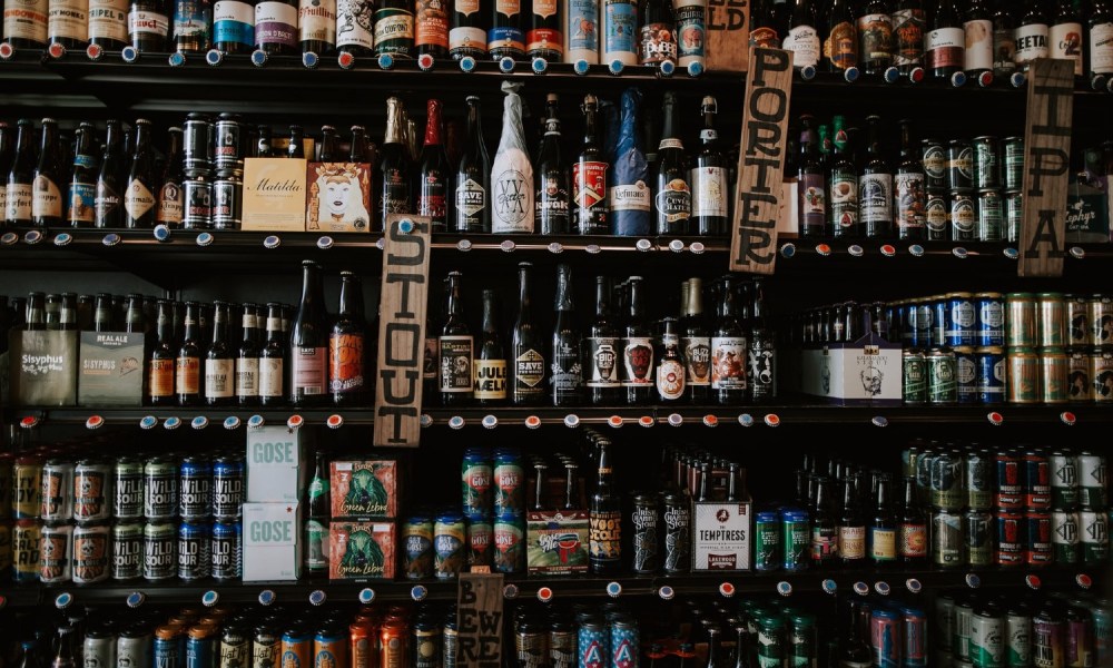 A shelf of stout beer next to porter and ipa.