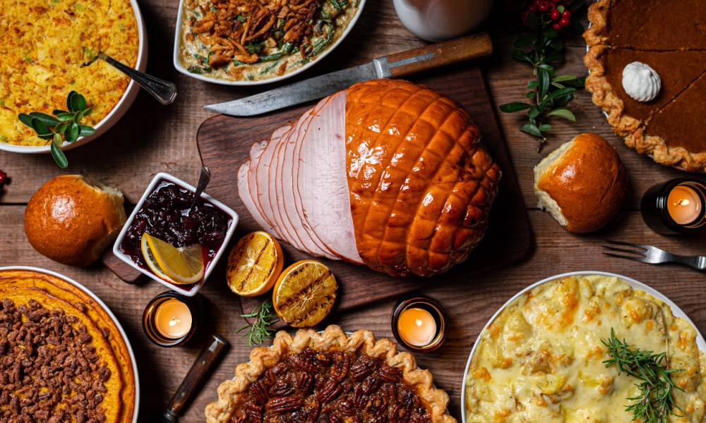 Thanksgiving meal with turkey breast, pies and casseroles on a table.