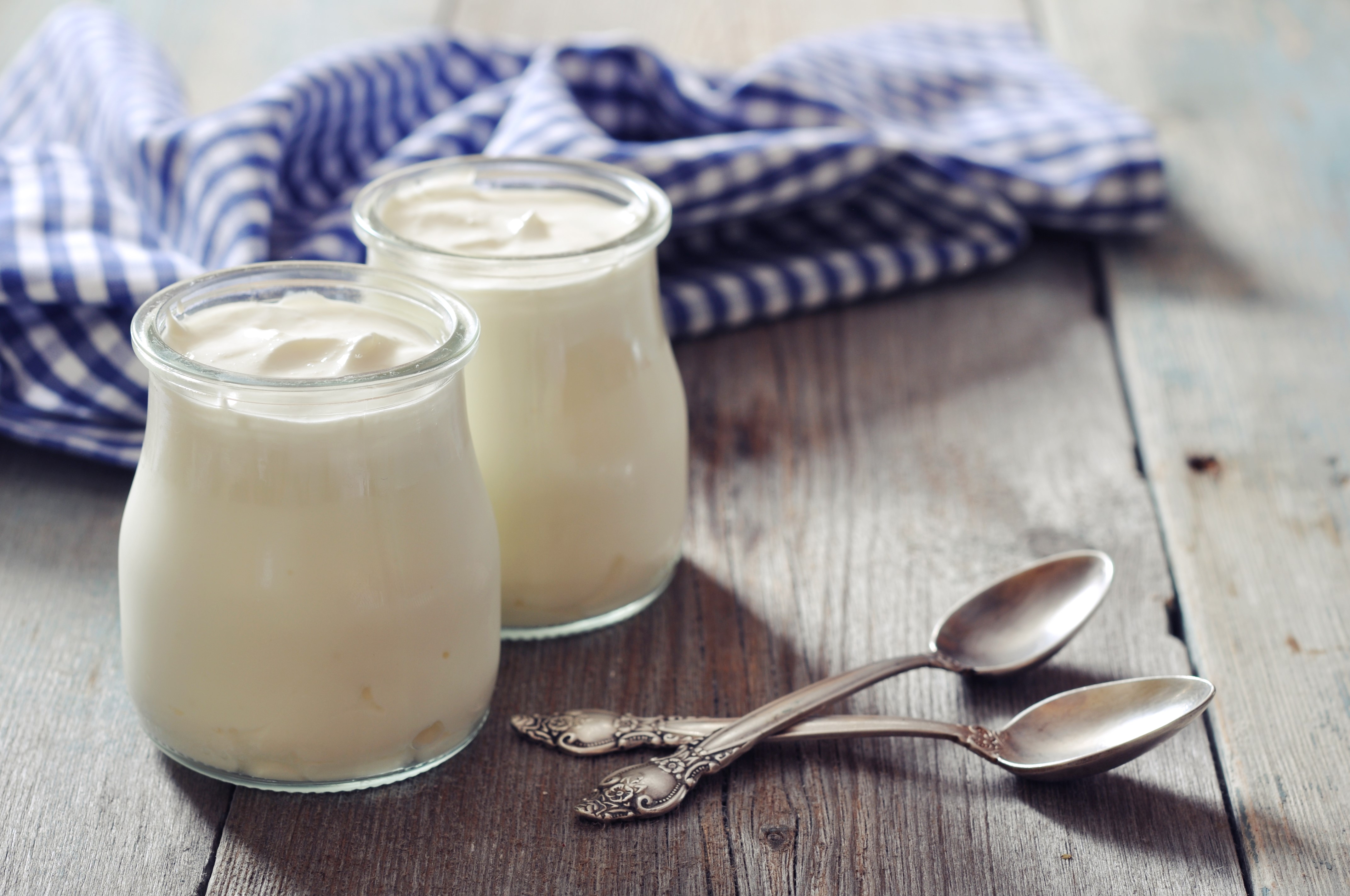 Two spoons and two jars of yogurt.