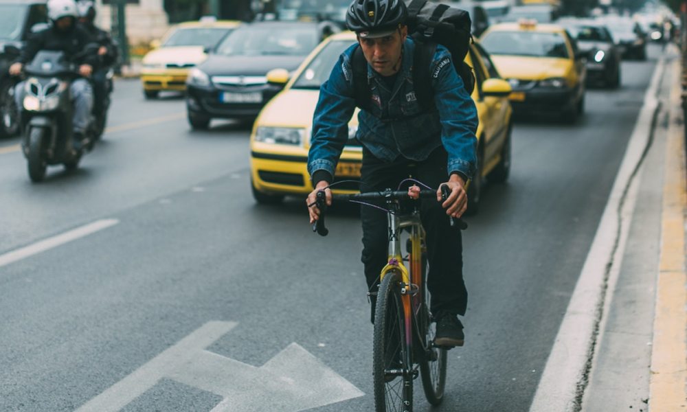 A man riding a bike in traffic.